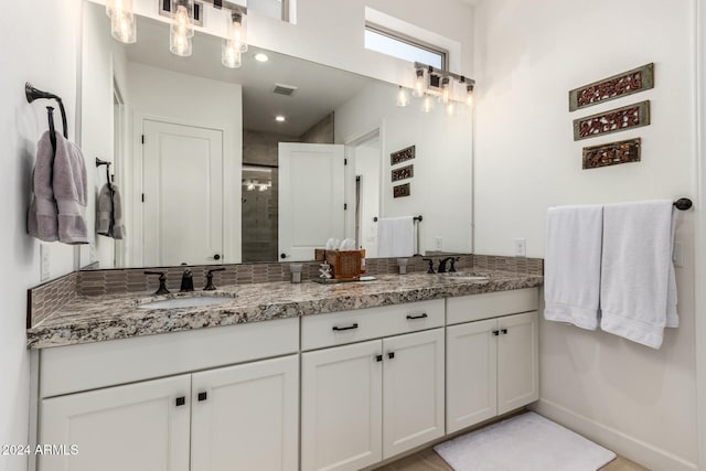 bathroom with a shower with door and vanity