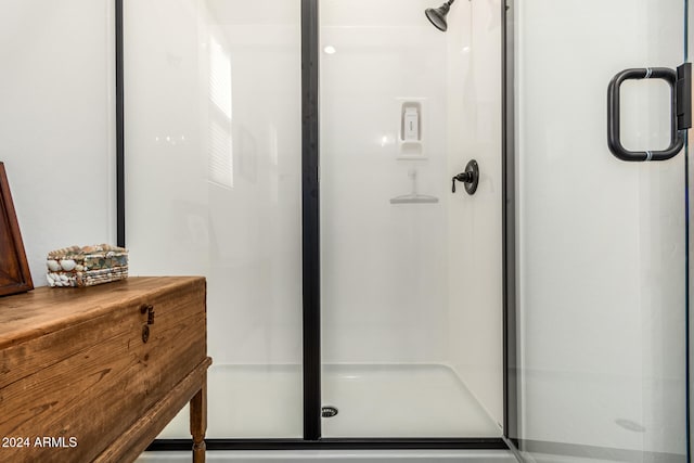 bathroom with a shower with door