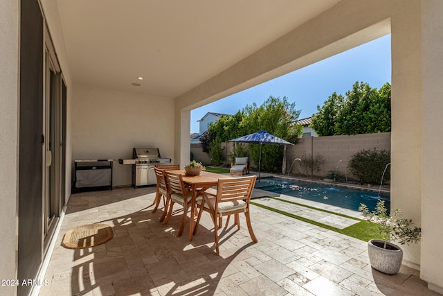 view of patio / terrace featuring pool water feature, a grill, and a fenced in pool