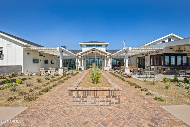 rear view of house featuring a pergola and a patio