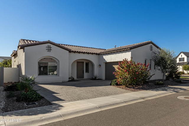 mediterranean / spanish-style house with a garage