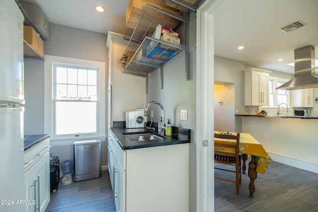 kitchen with island exhaust hood, white cabinetry, sink, and dark hardwood / wood-style flooring