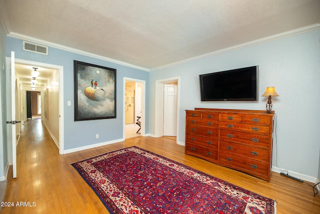 living room with ornamental molding, a textured ceiling, and wood-type flooring