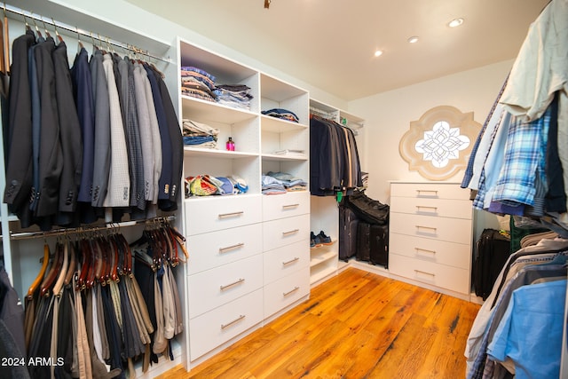 walk in closet with light hardwood / wood-style flooring