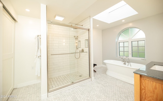 bathroom with vanity, a skylight, and separate shower and tub