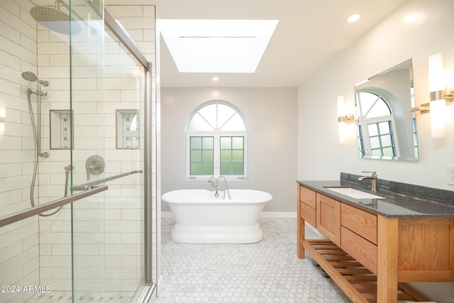 bathroom featuring vanity, a healthy amount of sunlight, a skylight, and separate shower and tub