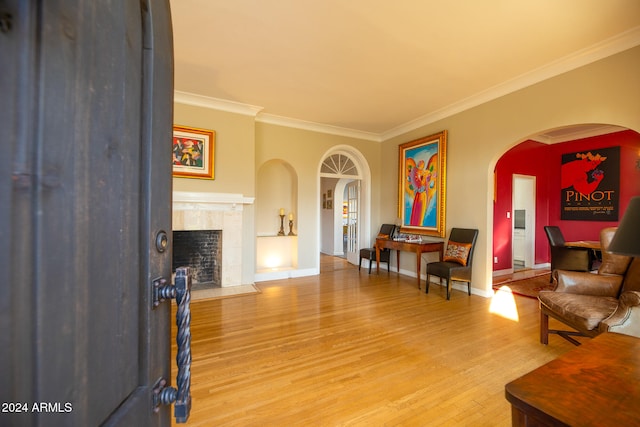 living room with crown molding, hardwood / wood-style floors, and a tile fireplace