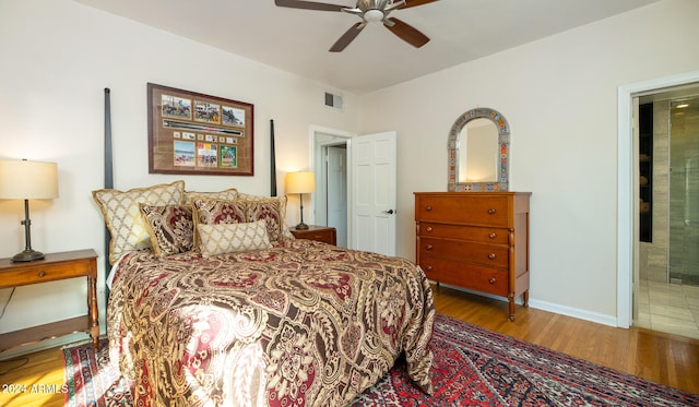 bedroom with hardwood / wood-style floors, connected bathroom, and ceiling fan