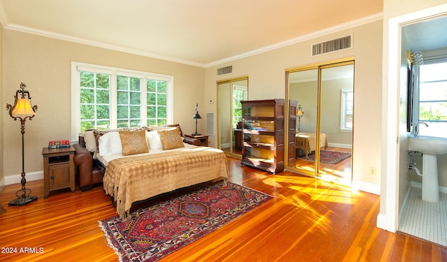 bedroom with multiple windows, ornamental molding, and wood-type flooring