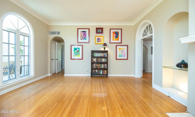 spare room featuring ornamental molding and light wood-type flooring