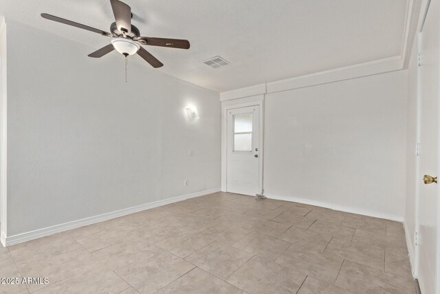 spare room with light tile patterned floors, visible vents, a ceiling fan, and baseboards