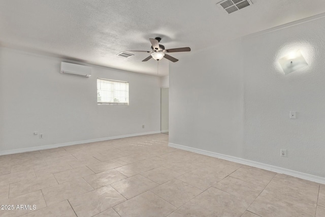 unfurnished room with visible vents, ceiling fan, a textured ceiling, and a wall mounted air conditioner