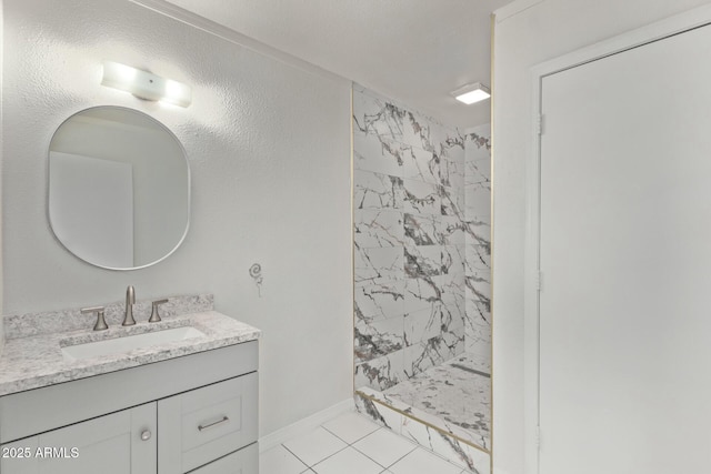 full bath with tile patterned floors, baseboards, a stall shower, and vanity