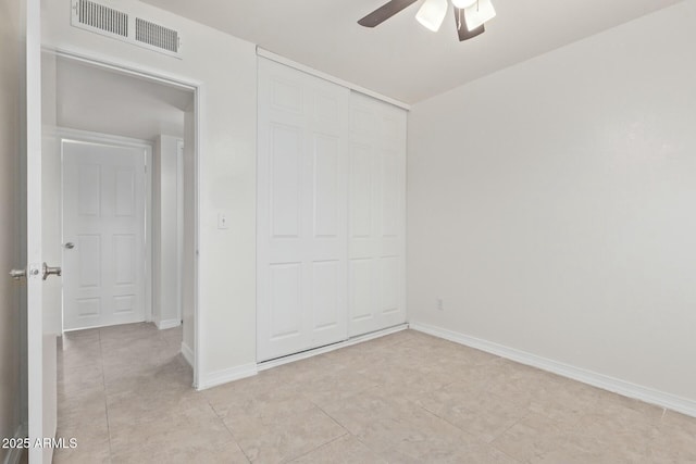 unfurnished bedroom with light tile patterned floors, a closet, visible vents, and baseboards