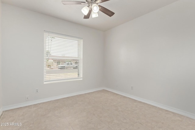 unfurnished room with a ceiling fan and baseboards