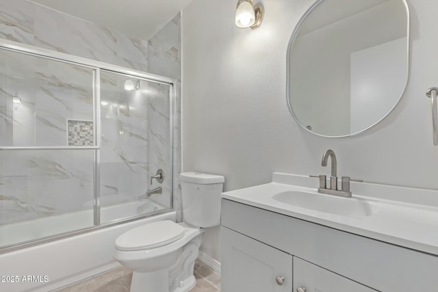 bathroom with toilet, enclosed tub / shower combo, vanity, and baseboards