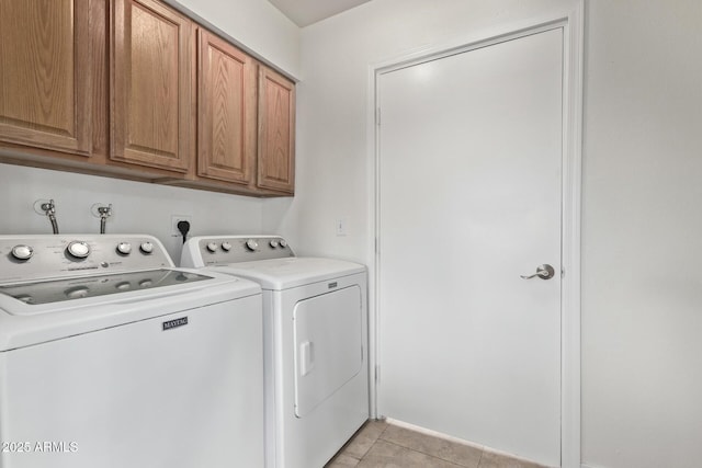 clothes washing area with light tile patterned floors, cabinet space, and independent washer and dryer