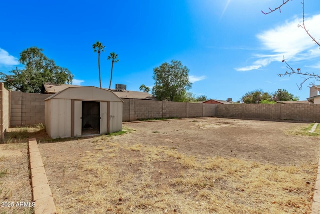 view of yard featuring an outbuilding, a shed, and a fenced backyard