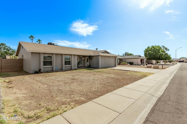 single story home featuring a garage, fence, and driveway