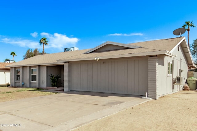 single story home with a garage, solar panels, and driveway