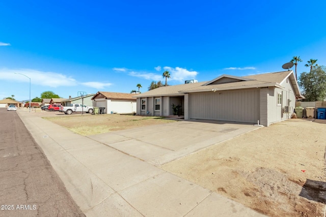 ranch-style home featuring concrete driveway and an attached garage