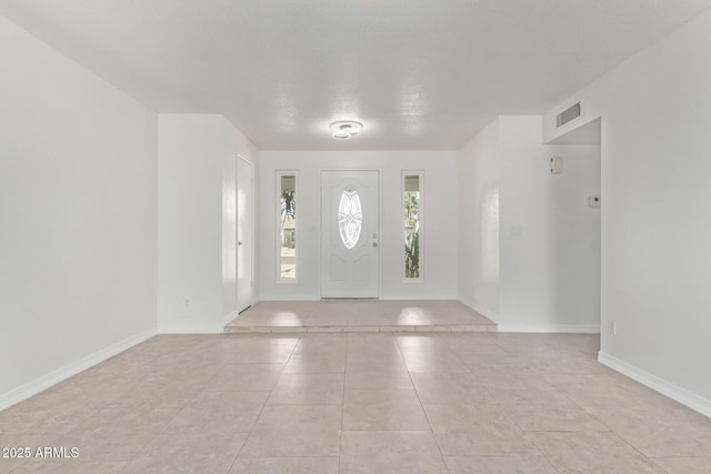 entrance foyer featuring light tile patterned floors, visible vents, and baseboards