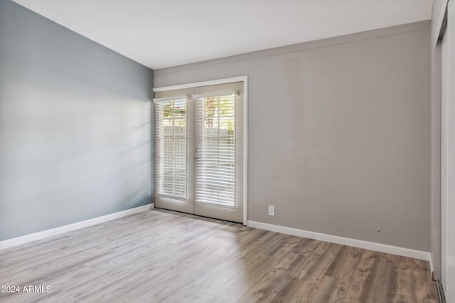 unfurnished room with french doors and light hardwood / wood-style floors