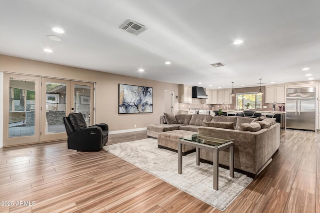 living room with french doors and light wood-type flooring