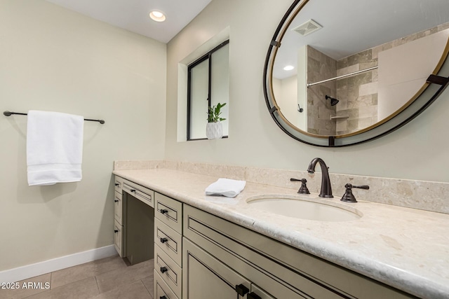 bathroom featuring vanity, tile patterned floors, and tiled shower