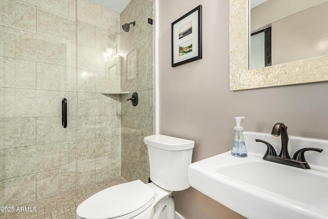 bathroom featuring toilet, a shower with door, and sink