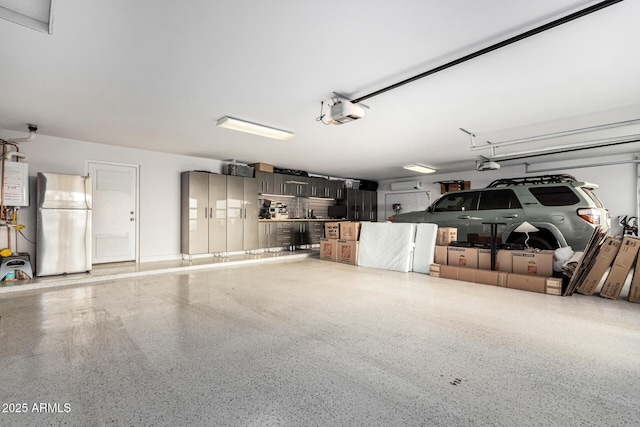 garage with water heater, a garage door opener, and stainless steel fridge