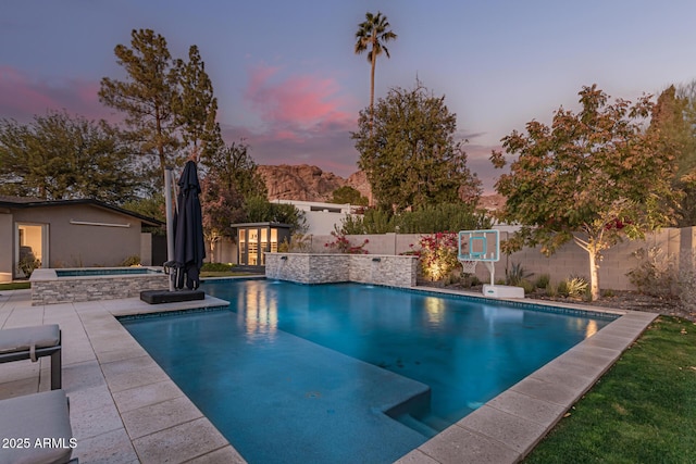 pool at dusk featuring a patio