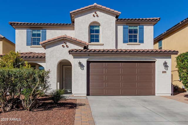 mediterranean / spanish-style home with driveway, a garage, and stucco siding