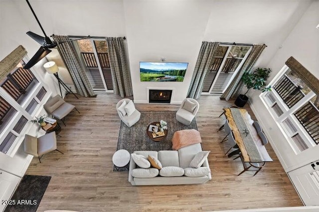 living room with wood-type flooring and a towering ceiling