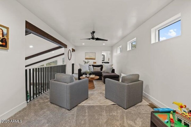 living room with beamed ceiling, light carpet, and ceiling fan