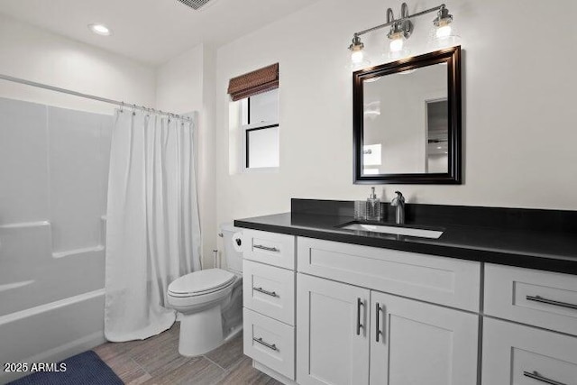 full bathroom featuring vanity, hardwood / wood-style floors, shower / tub combo with curtain, and toilet