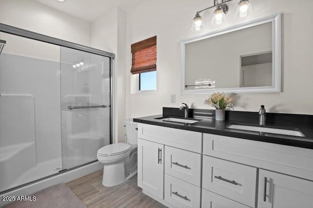 bathroom featuring toilet, vanity, and walk in shower