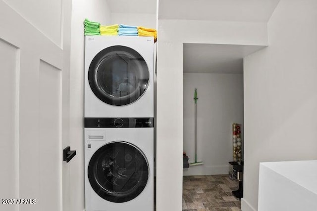 clothes washing area featuring stacked washer / dryer