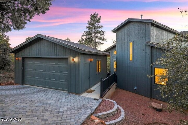 property exterior at dusk with an outbuilding and a garage