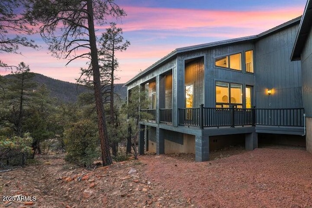 exterior space featuring a deck with mountain view and a sunroom