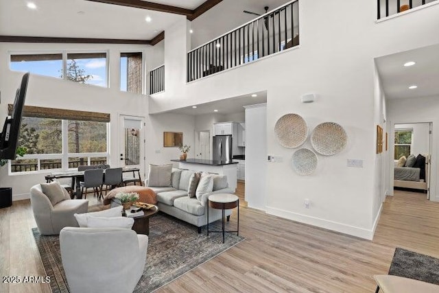 living room featuring beamed ceiling and light wood-type flooring