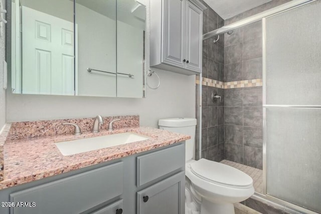 bathroom with vanity, toilet, and a shower stall