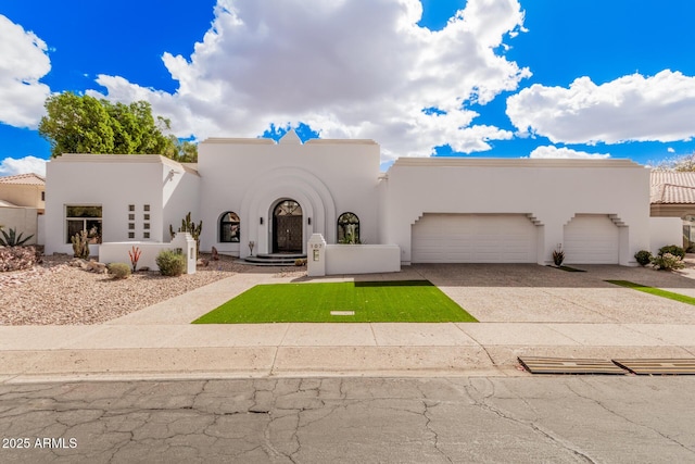 view of front of property featuring a garage, driveway, and stucco siding