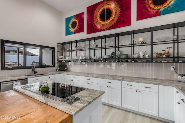 bar with dishwasher, black electric stovetop, a sink, and tasteful backsplash