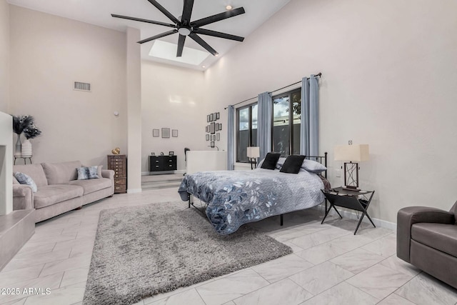 bedroom with marble finish floor, visible vents, a high ceiling, ceiling fan, and baseboards