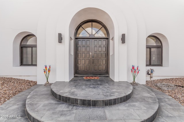 doorway to property featuring stucco siding