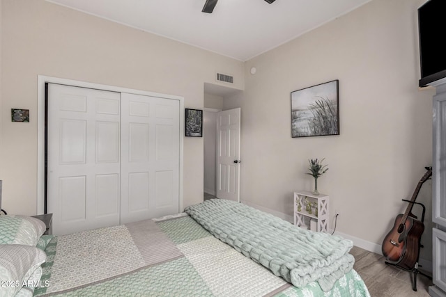 bedroom with ceiling fan, visible vents, baseboards, a closet, and light wood finished floors