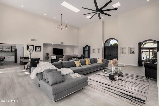 living area with light wood-type flooring, a skylight, visible vents, and recessed lighting