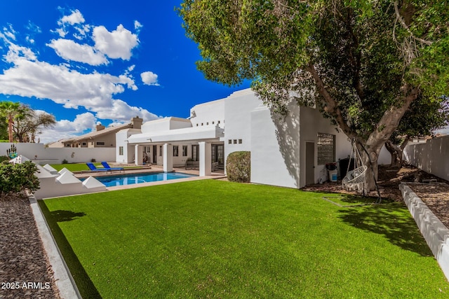 back of house with a patio, a fenced backyard, a yard, a fenced in pool, and stucco siding