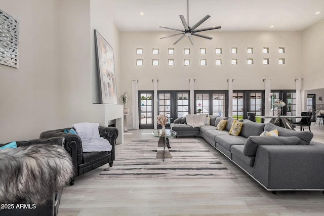 living area with a high ceiling, wood finished floors, and recessed lighting